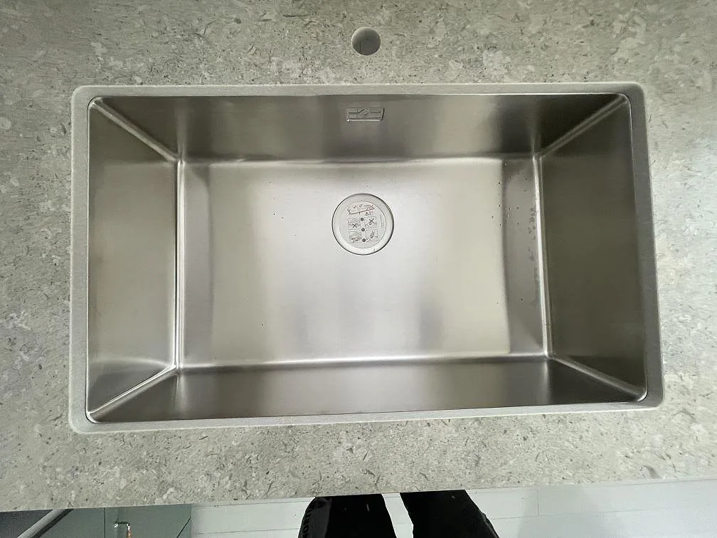 Underlimmad rostfri diskho i grå Dekton VK03 Grigio bänkskiva, matt keramik, i ett kök i Värmdö.