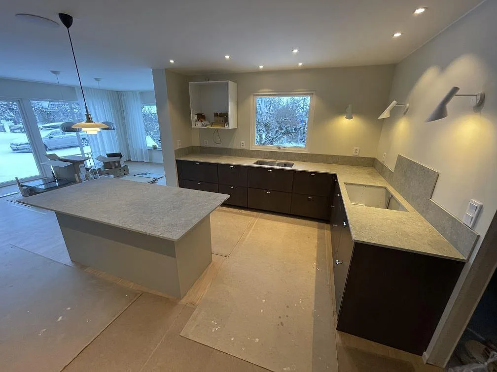 Kök i Vreta Kloster med matt grå Dekton VK03 Grigio på köksö och bänk, med urtag för diskho och häll under montering.