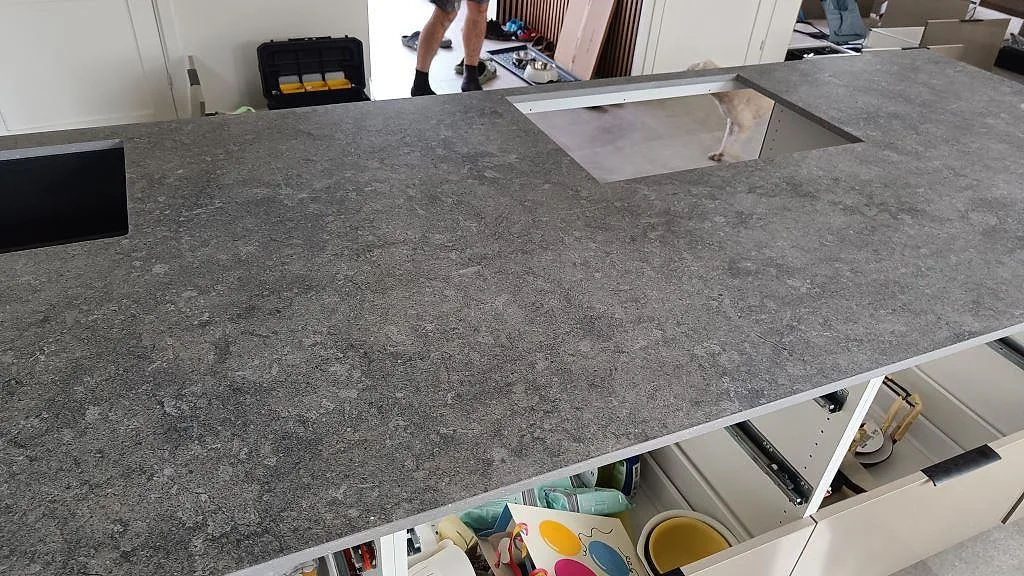 Matt Dekton Vk04 Grafite som köksbänkskiva med bred grå yta, svart ho och rektangulär öppning i Höllviken.
