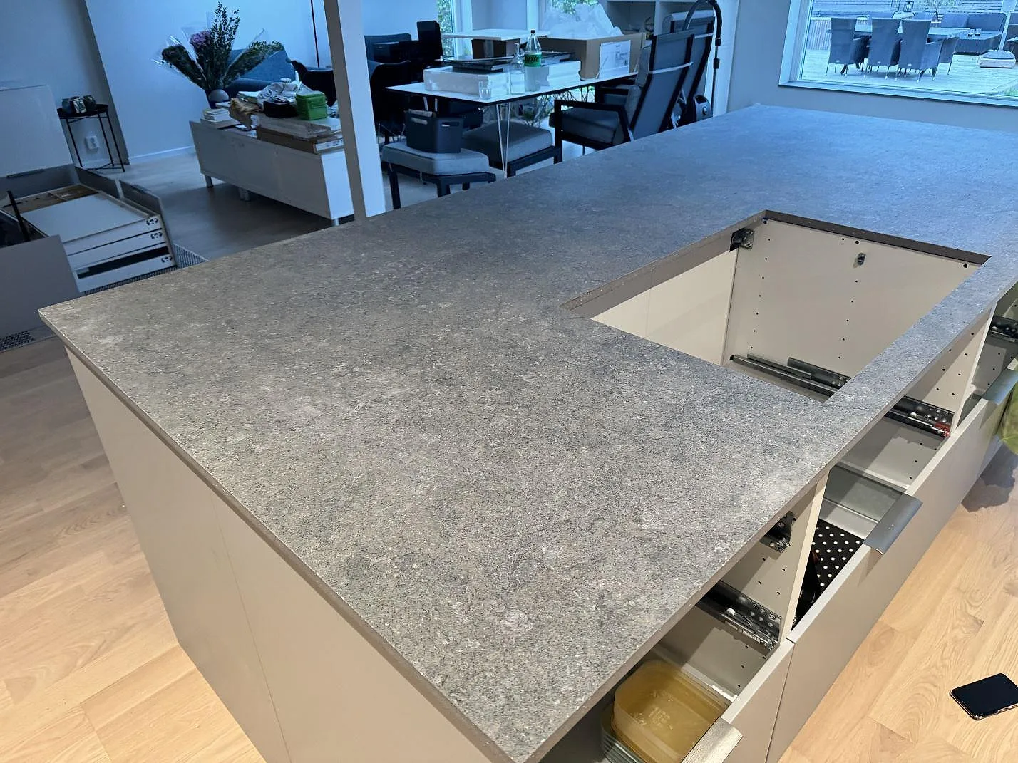 Köksö i matt Dekton Vk04 Grafite sedd ovanifrån, med grå stenstruktur och förberedd öppning i köket i Lomma.