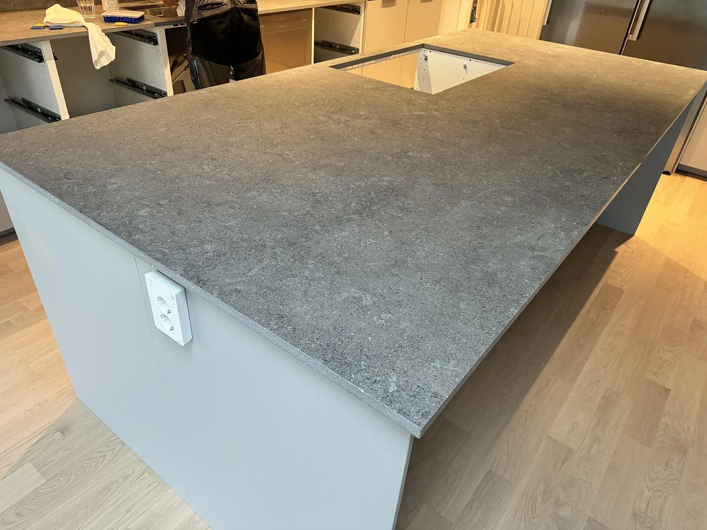 Stor köksö i matt Dekton Vk04 Grafite, grå keramisk bänkskiva med öppning och synlig kant i Lomma.