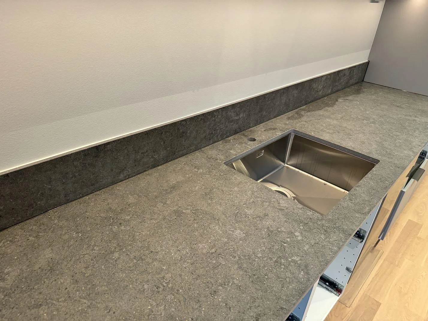 Köksbänkskiva i matt Dekton Vk04 Grafite med rostfri diskho och uppvikt stänkskydd i Lomma.