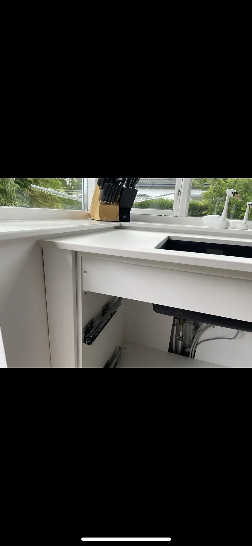 Köksbänkskiva i matt vit Dekton Zenith, keramik, med underlimmad diskho och vit blandare vid fönster i ett kök i Hellerup.