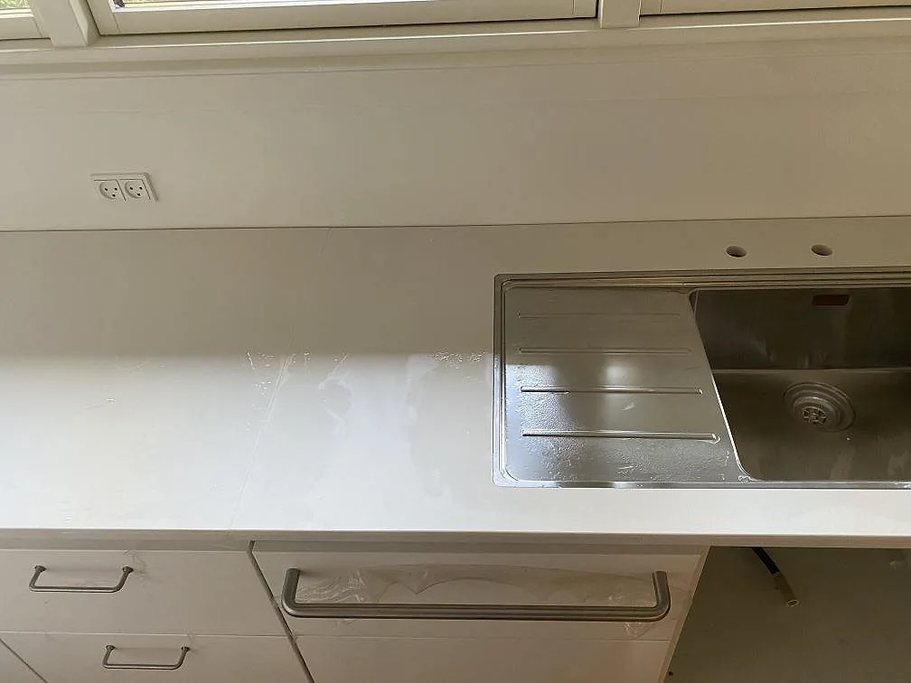 Matt vit Dekton Zenith som köksbänkskiva i Holte med rostfri diskho och avrinningsyta ovanpå stenen.