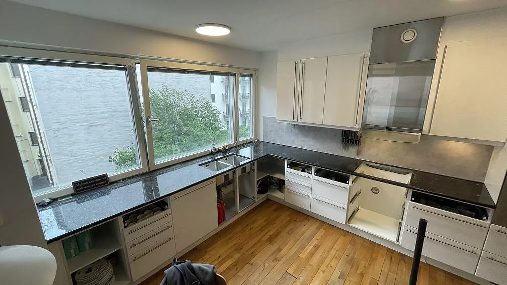 Köksbänkskiva i polerad Emerald Pearl granit i ett L-format kök i Malmö, fotograferad under montering.