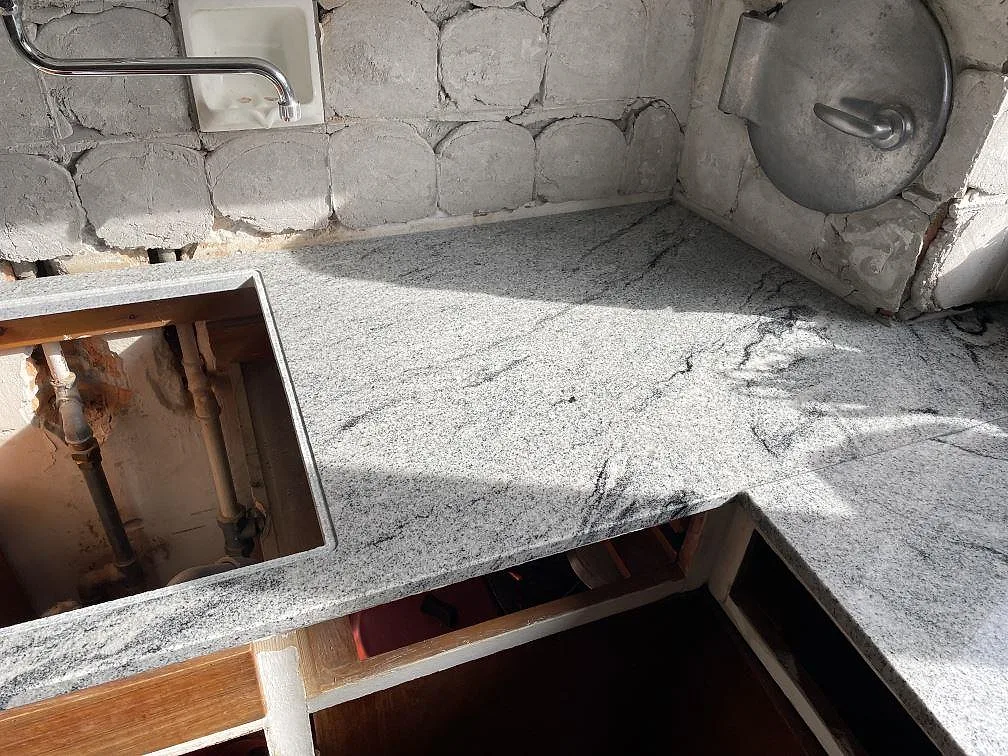 Närbild på polerad Emerald Pearl granit som köksbänkskiva med synligt diskbänksurtag och mörk ådring i Ringsted.