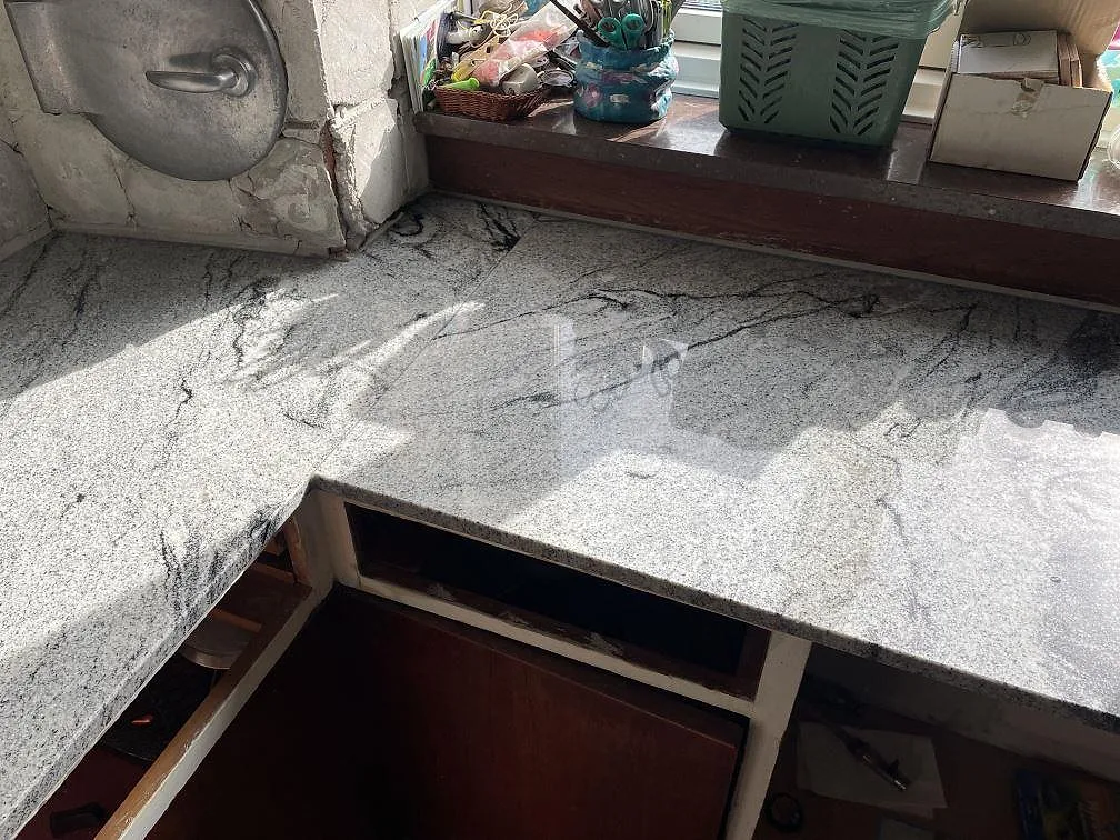 Polerad Emerald Pearl granit vid fönstret i ett kök under montering i Ringsted, med tydliga reflexer och ådring.