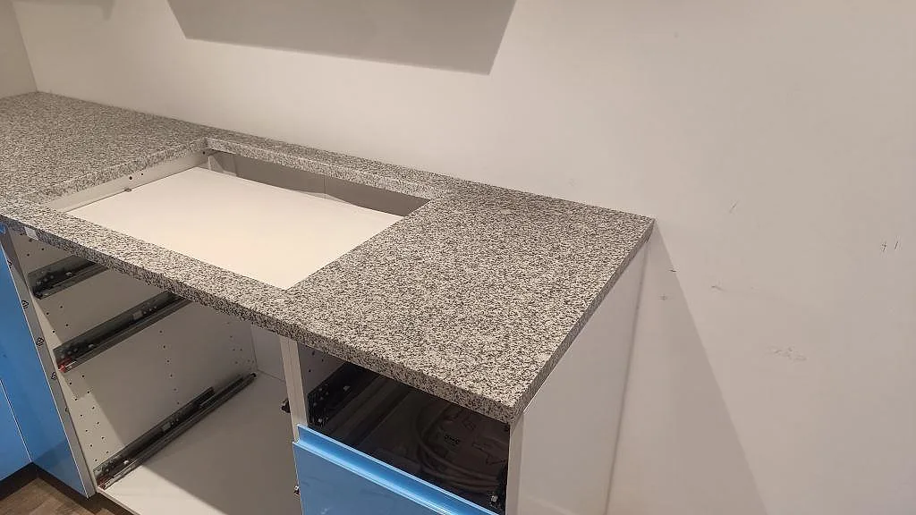 Sidovy av installerad Grigio Cristallo granitskiva, polerad, med rektangulär hällöppning i Laholm.