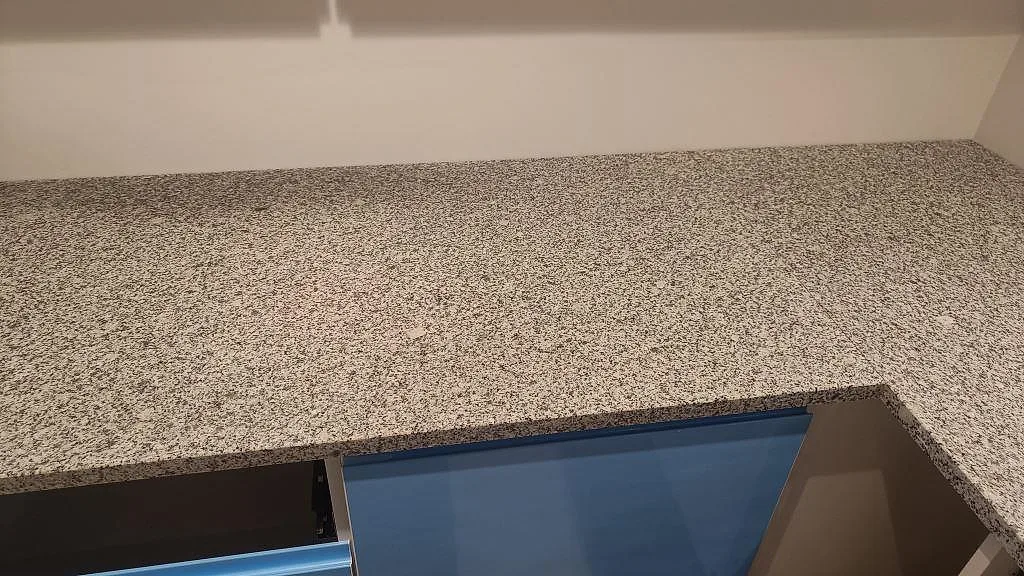Polerad Grigio Cristallo granit som lång arbetsyta ovanför blå köksluckor i Laholm.