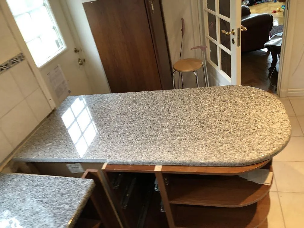 Polerad köksö i granit Grigio Cristallo med mjukt rundad gavel och halvrundad kant i ett kök i Onsala.