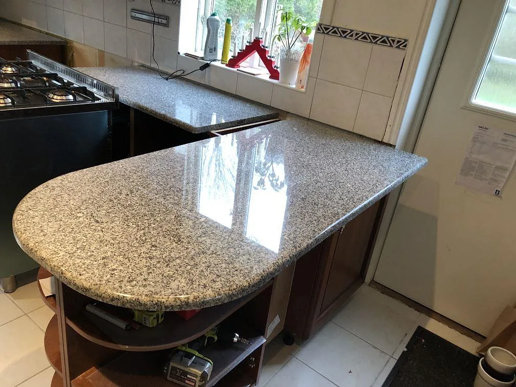 Närbild på köksbänkskiva i granit Grigio Cristallo med urtag för underlimmad diskho i ett kök i Onsala.