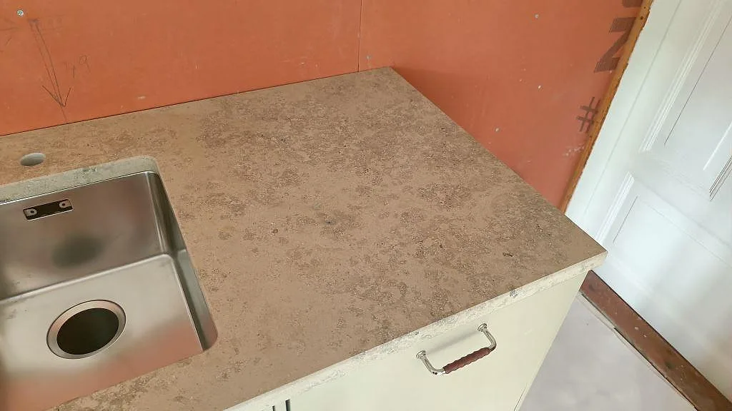 Kökshörn i Jura Grey kalksten med underlimmad rostfri diskho och borrat blandarhål i ett kök i Båstad.