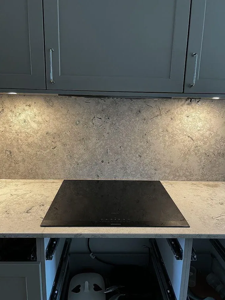 Köksbänkskiva i matt Jura Grey kalksten med hällöppning och fossiltecknad väggyta i Bankeryd.
