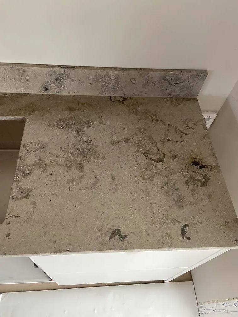 Uppvikt stänkkant i Jura Grey kalksten mot bänkskivan med tydlig fossilådring i ett kök i Bunkeflostrand.
