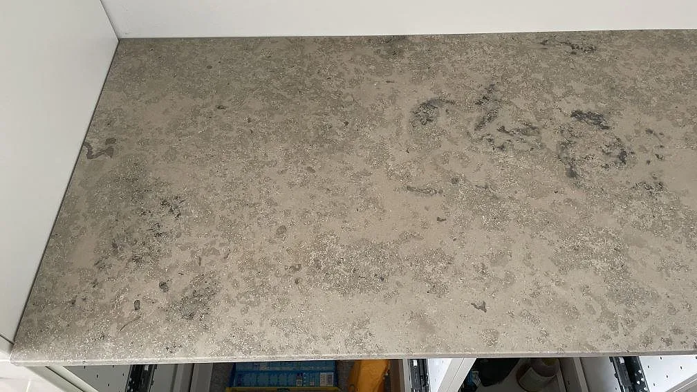 Ovanifrån av matt Jura Grey kalkstensbänk med sandig fossilstruktur i ett kök i Espergærde.