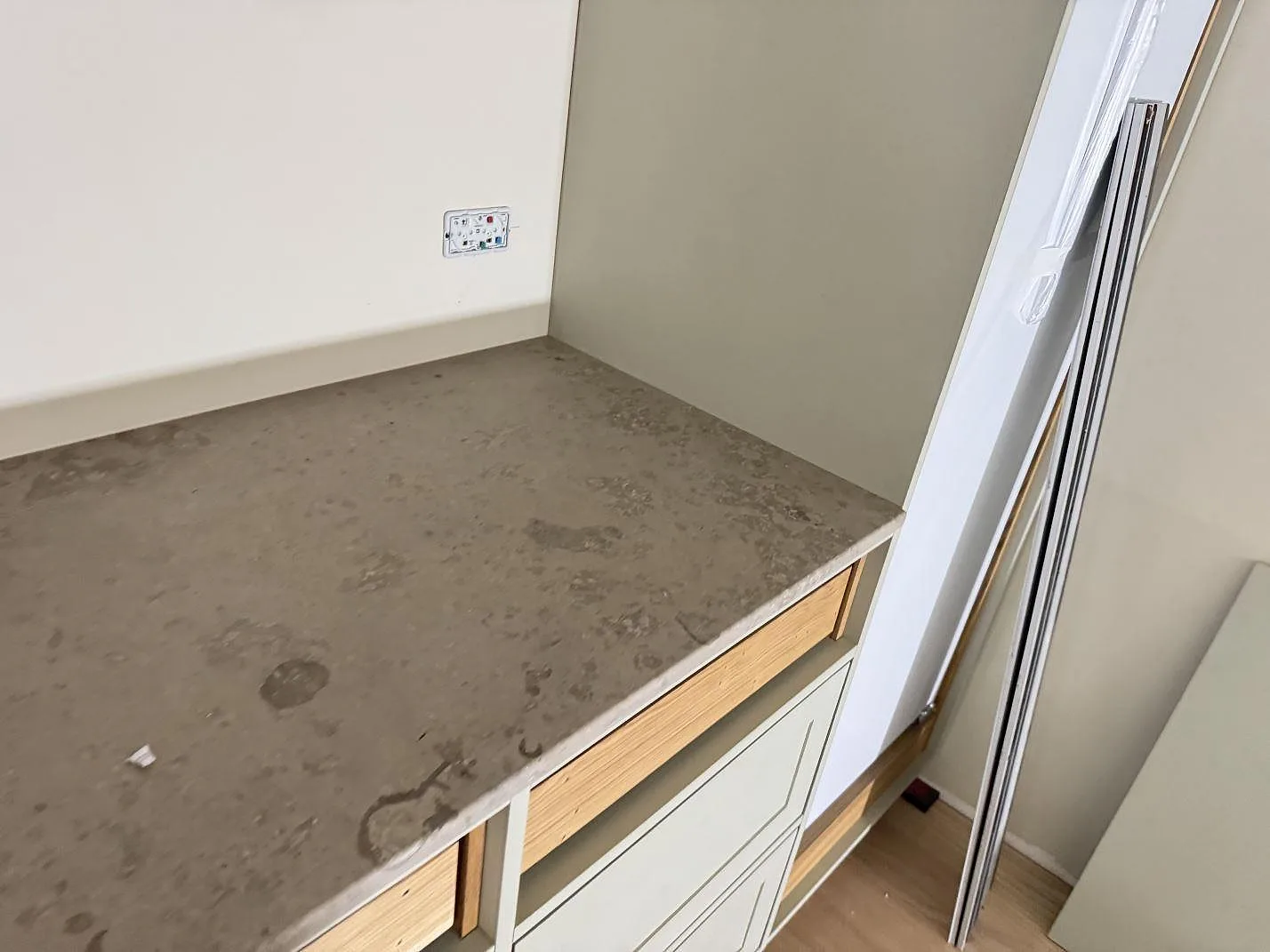 Hörndetalj av matt Jura Grey bänkskiva med grå teckning och öppen inredning i Espergaerde.