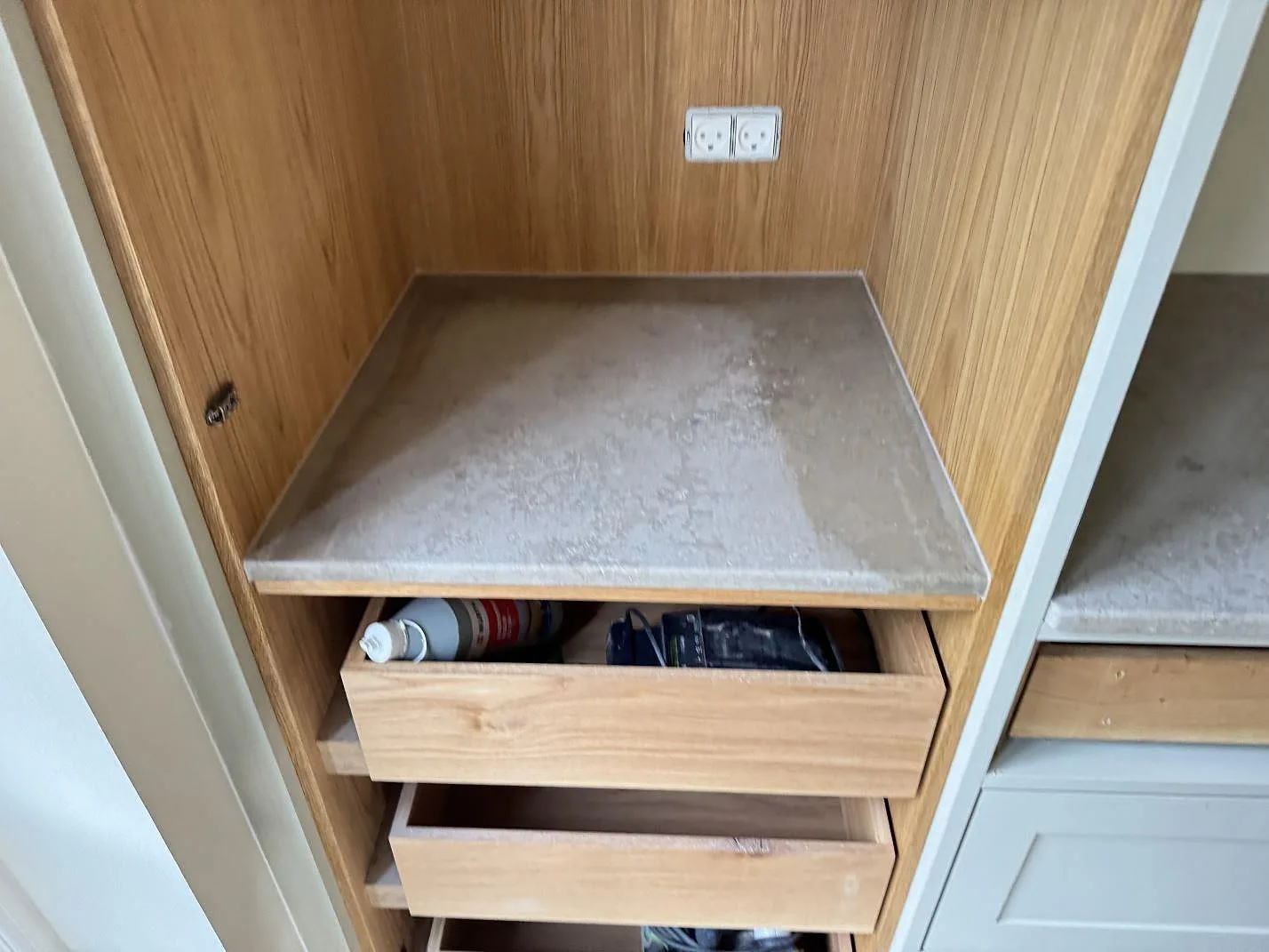 Mindre bänkskiva i matt Jura Grey kalksten i träinredning med lådor under montering i Espergaerde.