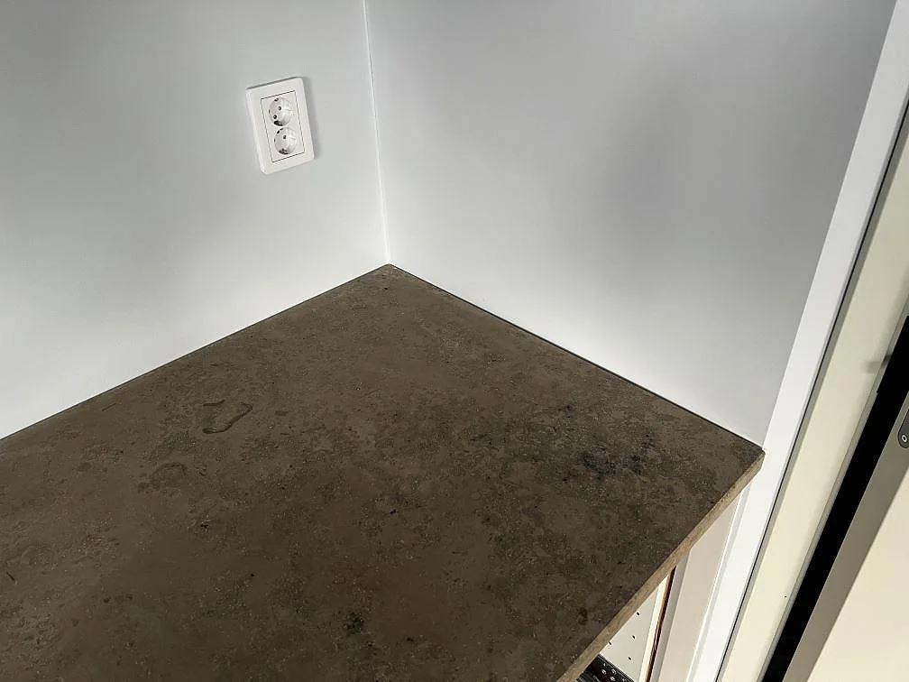 Installerad matt Jura Grey bänkskiva mot ljus vägg med tydlig naturstensyta i Falsterbo.