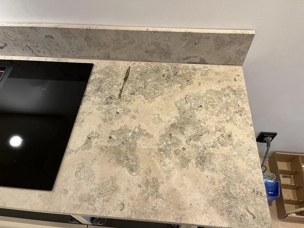 Detalj av Jura Grey kalksten med naturlig fossilådring och kalkådra på en matt köksbänkskiva i Göteborg.