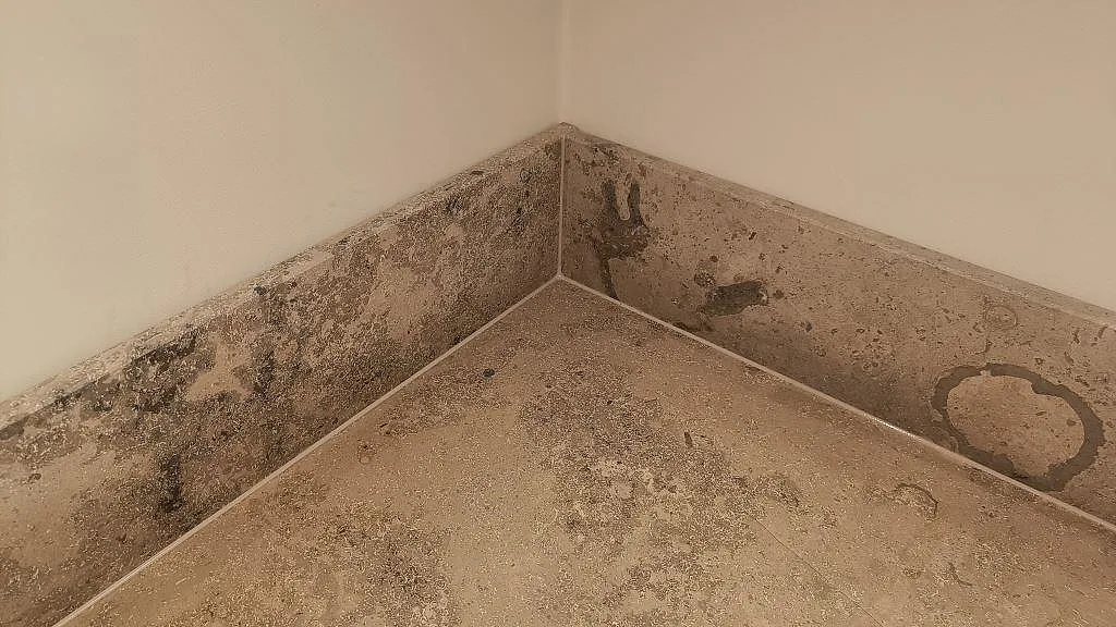 Närbild av stänkkant och bänkskiva i matt Jura Grey kalksten med tydlig fossilstruktur i Göteborg.