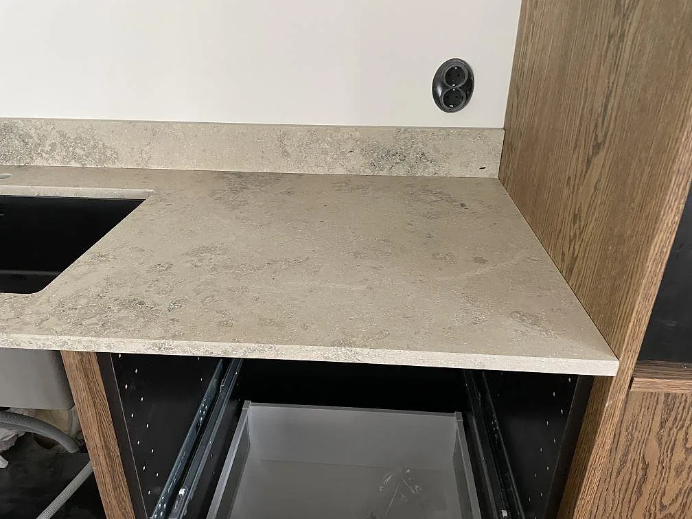 Hörn av matt Jura Grey köksbänkskiva med uppvikt stänkkant och underlimmad diskho i ett kök i Halmstad.