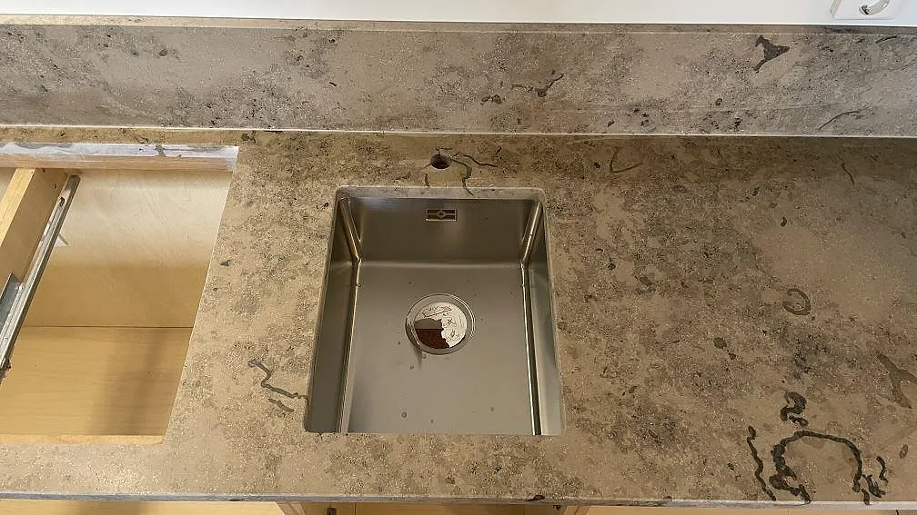 Topvy över matt Jura Grey kalksten kring diskho och intilliggande köksstomme i Helsingborg.