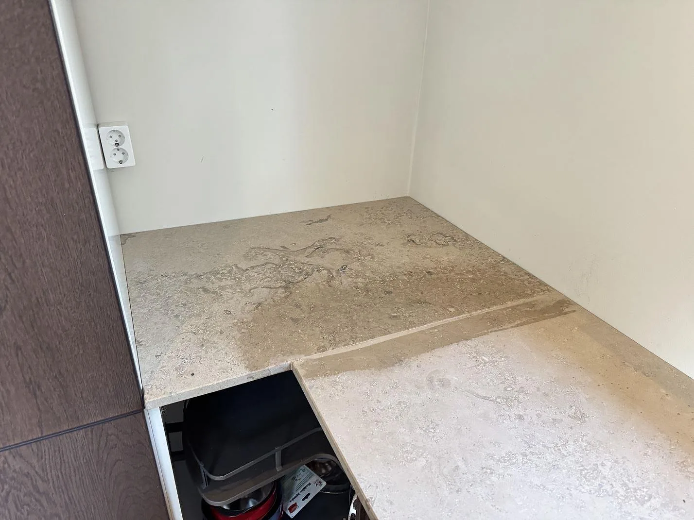 Köksbänkskiva i beige-grå Jura Grey-kalksten, matt yta med tydliga fossilspår, monterad i vinkel längs en köksvägg i Helsingborg.