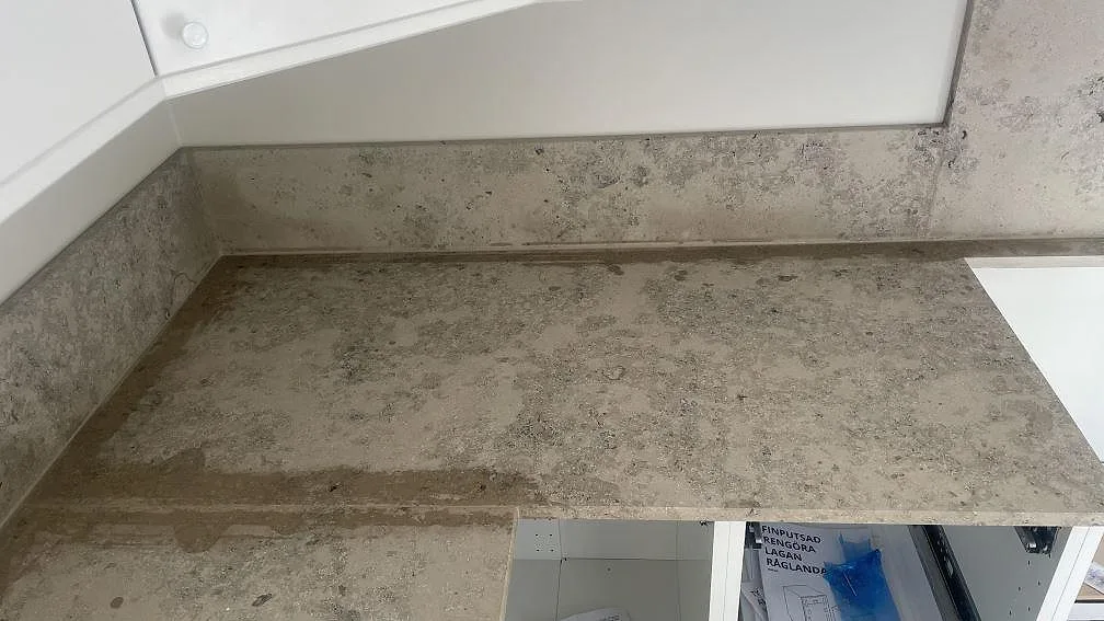 Närbild på matt Jura Grey köksbänkskiva och stänkskydd med fossilrik grå kalkstensyta i Hindås.