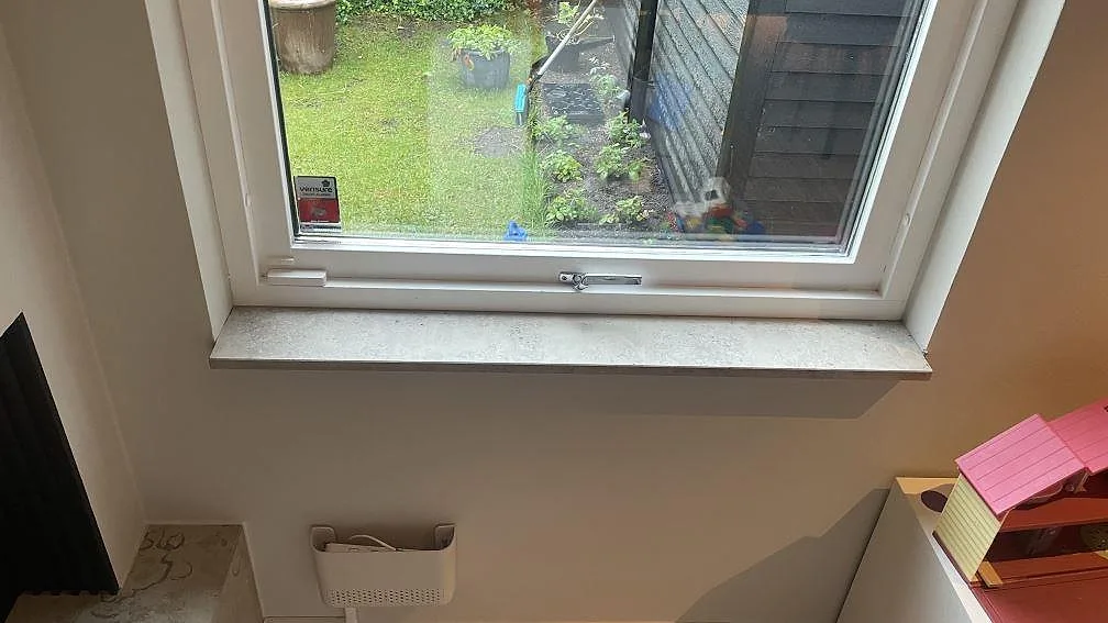 Matt Jura Grey kalksten som smal fönsterbänk i ett ljust rum med trädgårdsutsikt i Höllviken.