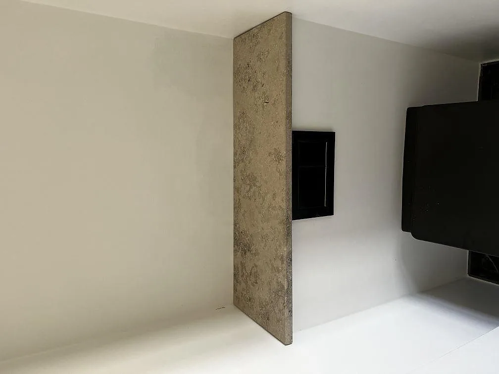 Avslutande stengavel i matt Jura Grey kalksten som rumsdelare i ett kök i København Ø.