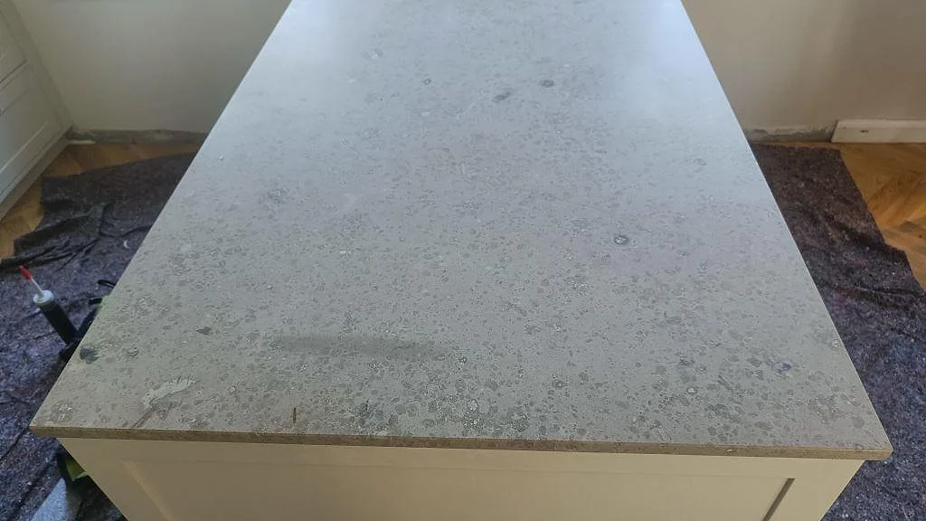 Närbild av halvö i matt Jura Grey kalksten med fossilrik gråbeige yta i Köpenhamn.