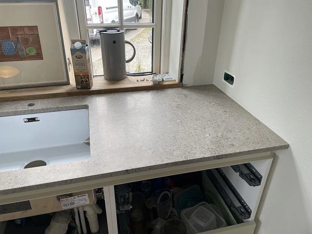 Diskbänk i Jura Grey kalksten med matt finish, vit underlimmad diskho och ljus fönsternisch i Kongens Lyngby.