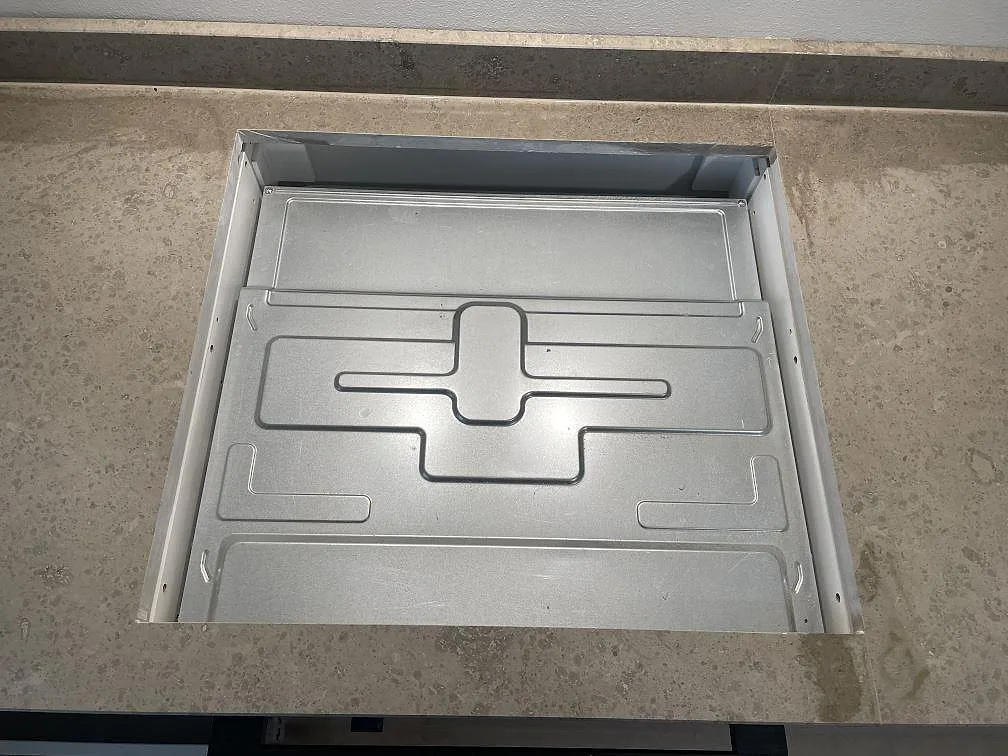 Hällurtag i matt Jura Grey kalksten med uppvikt stänkkant på en köksbänkskiva i Kortedala.