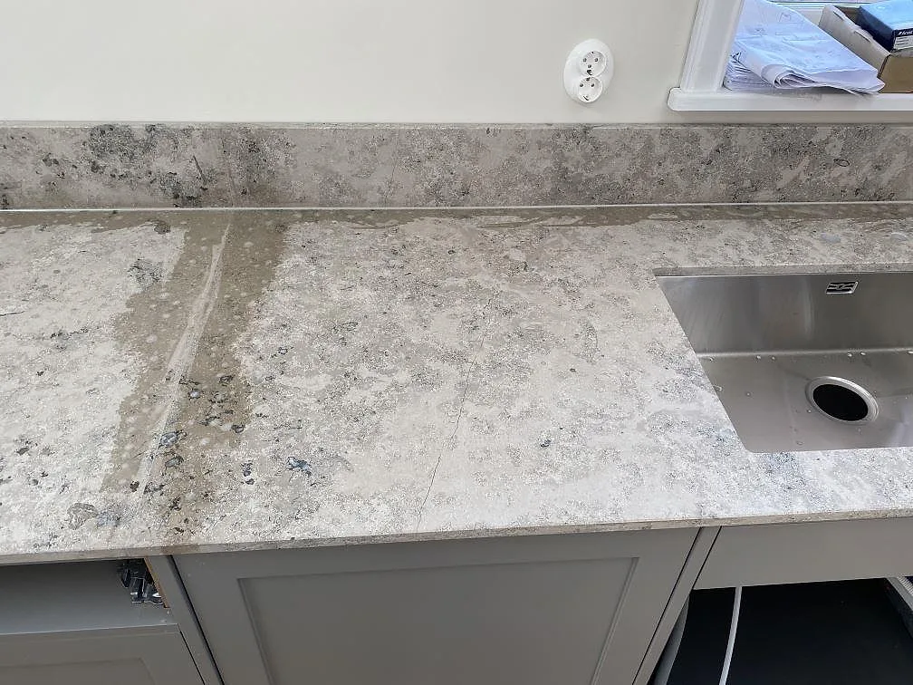 Närbild på matt Jura Grey köksbänkskiva med underlimmad rostfri diskho och uppvikt stänkkant i Kungshamn.