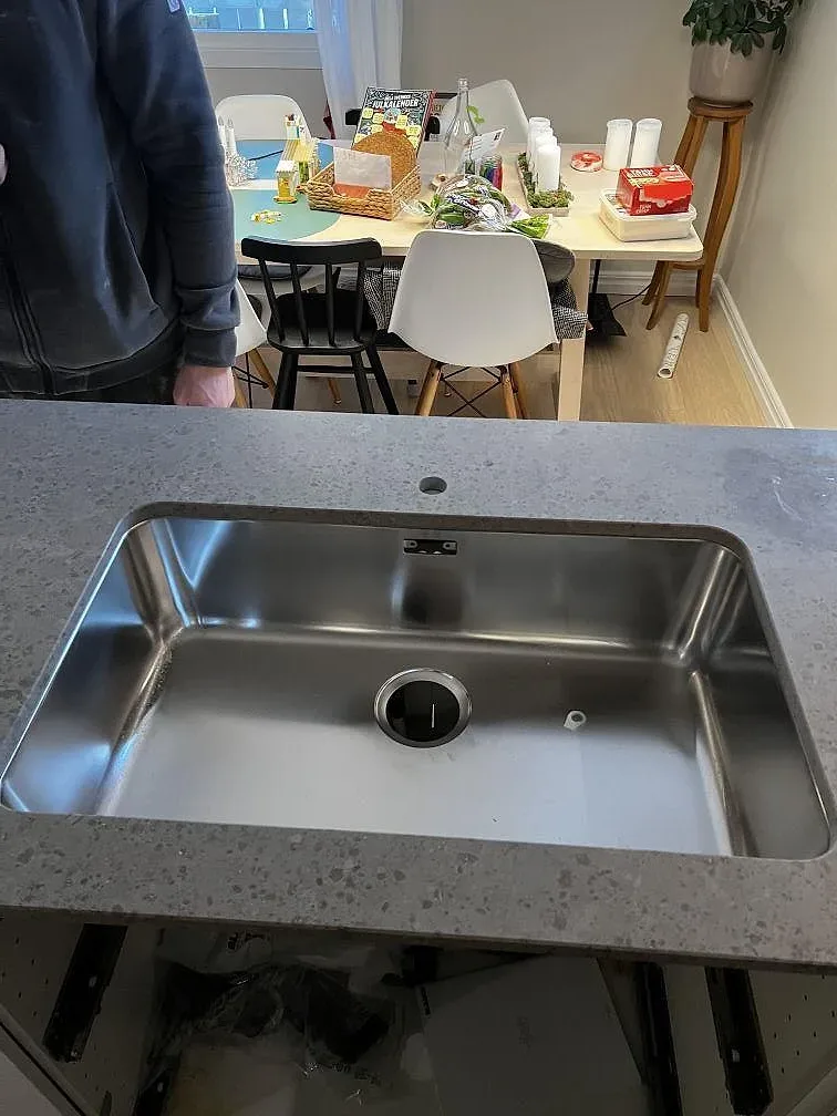 Rostfri diskho monterad under en matt Jura Grey köksbänkskiva i Landvetter.