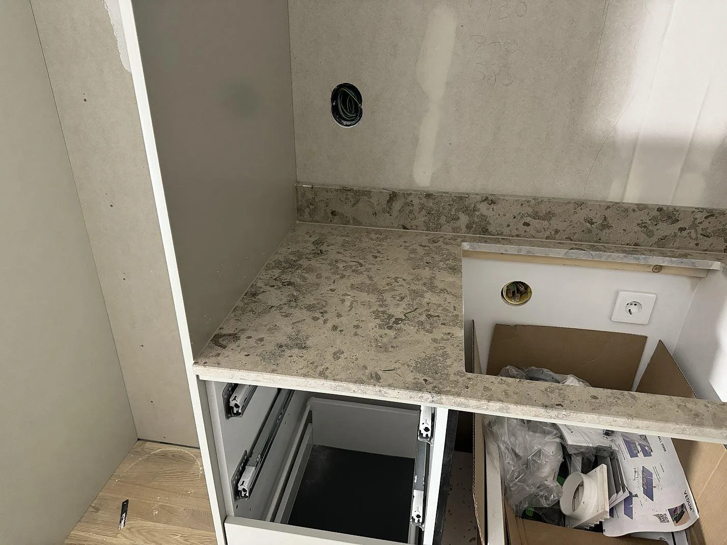 Närbild på Jura Grey kalksten med fossil struktur, matt yta och diskhourtagen i ett kök i Landvetter.