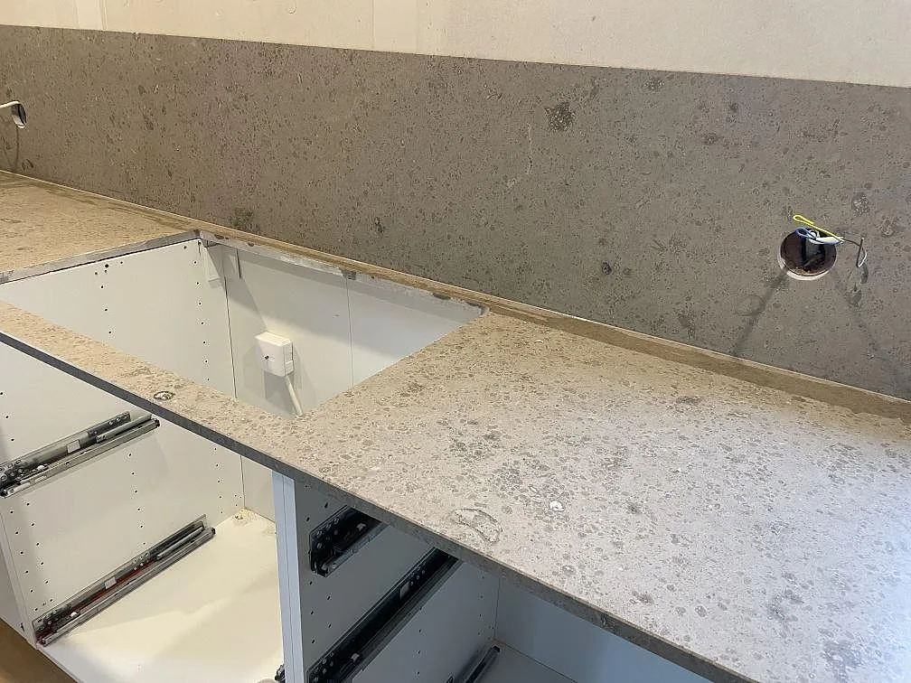 Matt Jura Grey köksbänkskiva med utskärning för häll och stänkskydd över öppna köksstommar i Lekeryd.