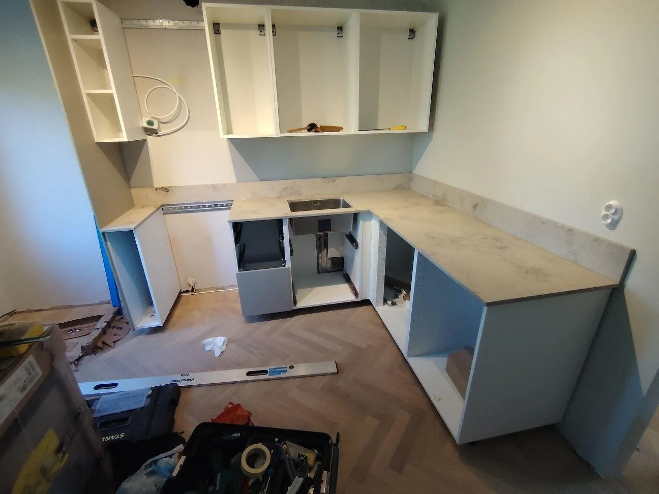 Köksbänkskiva i Jura Grey kalksten, matt, med låg stänkkant i ett kök under montering i Lidingö.