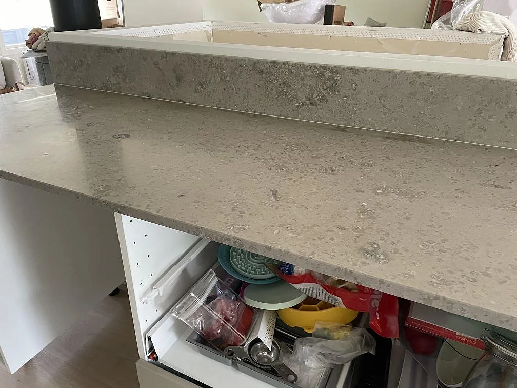 Detalj av matt Jura Grey köksbänkskiva med fossilrik grå yta och uppvikt stänkkant i Lindome.