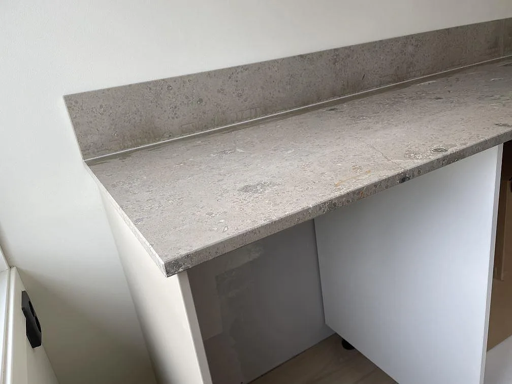 Gavel och lång yta i matt Jura Grey kalksten monterad som köksbänkskiva med stänkkant i Lindome.