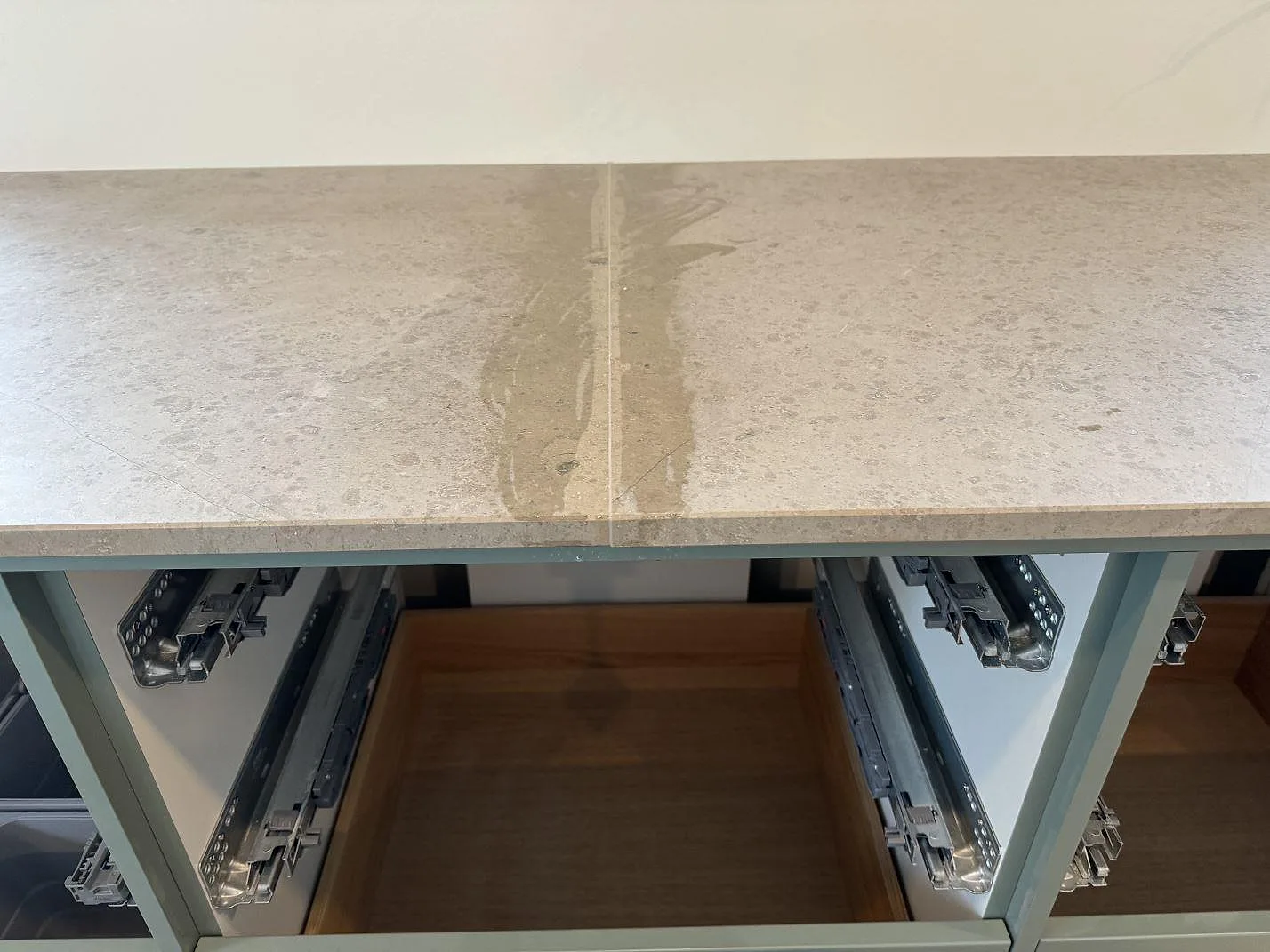 Detalj av skarv och fossilstruktur i matt Jura Grey köksbänkskiva under montering i Lyngby.