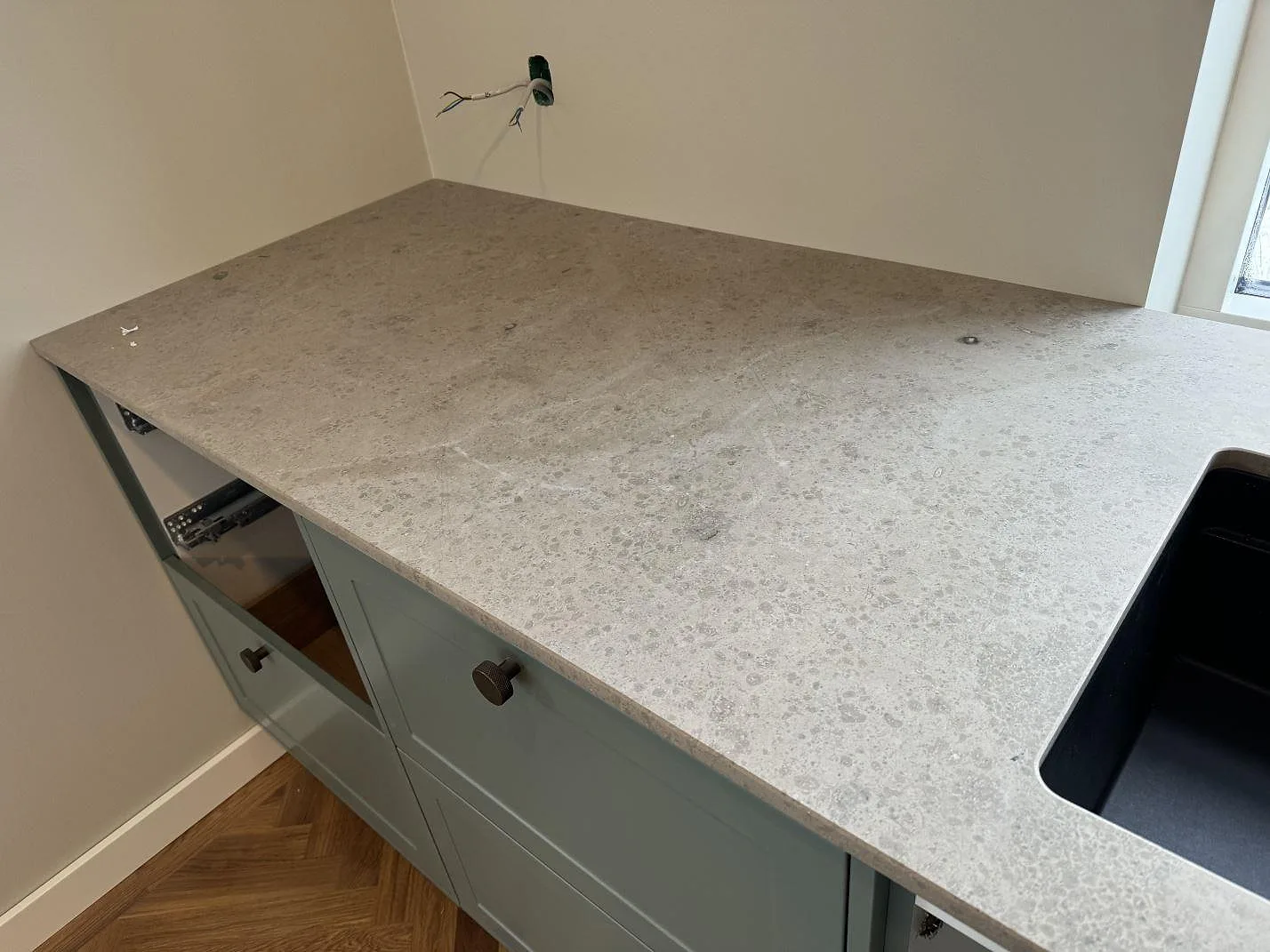 Jura Grey köksbänkskiva i matt yta med arbetsyta bredvid den svarta diskhon i Lyngby.