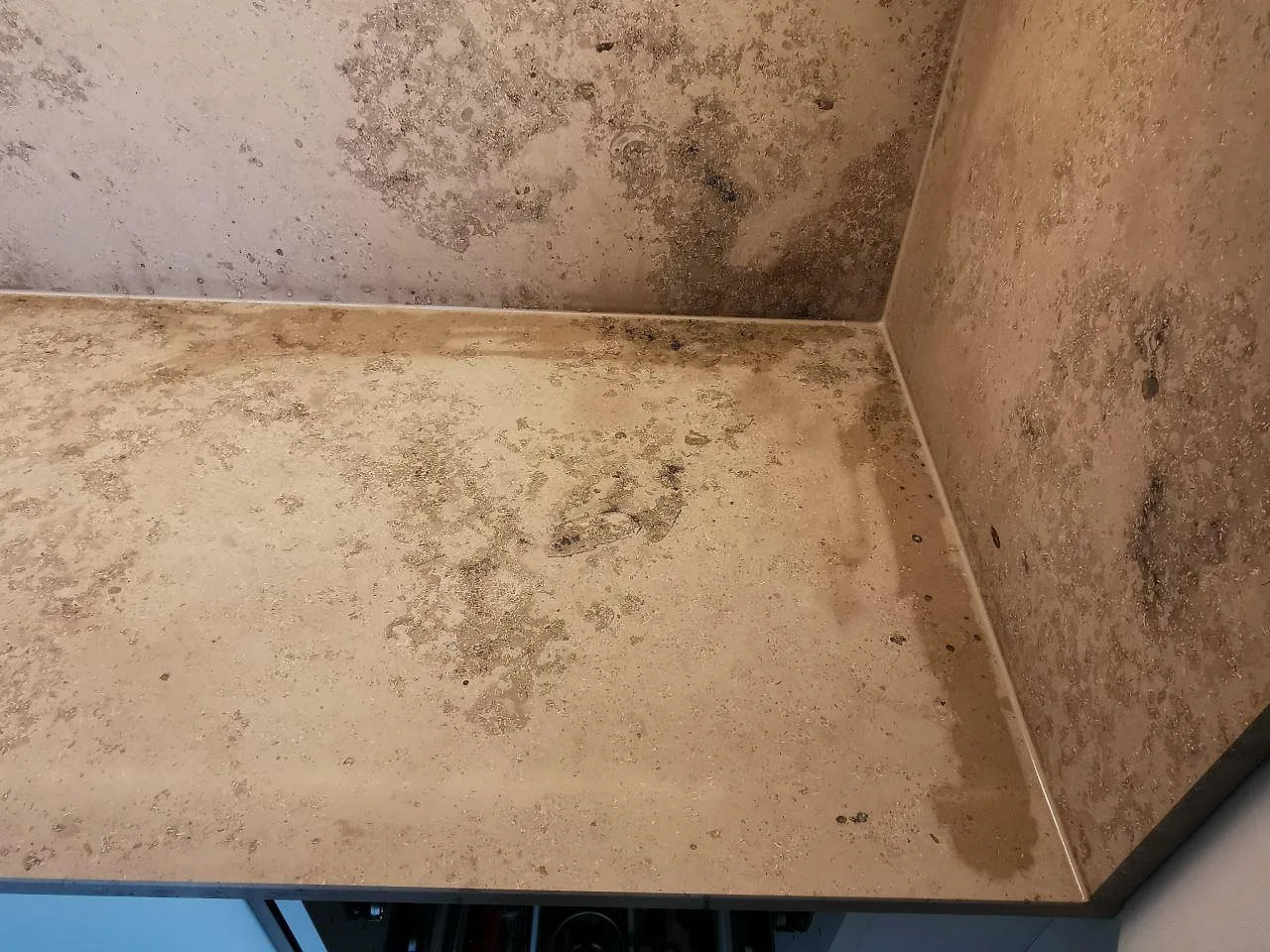 Detalj av matt Jura Grey kalkstensbänk mot stänkskydd i samma sten, fossilrik struktur i ett kök i Malmö.