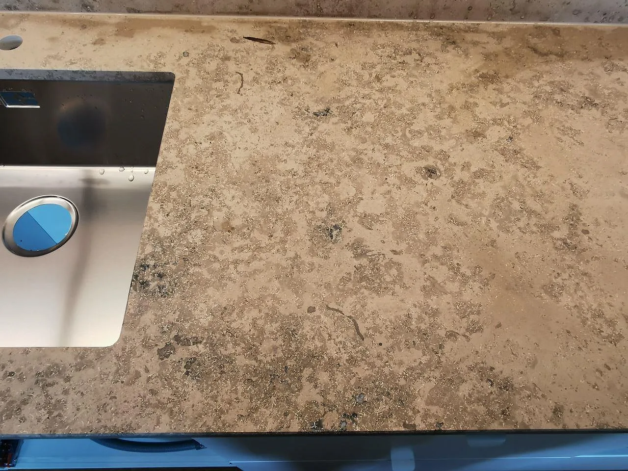 Närbild på matt Jura Grey köksbänkskiva i kalksten med rostfri diskho och naturlig grågul melering, kök i Malmö.