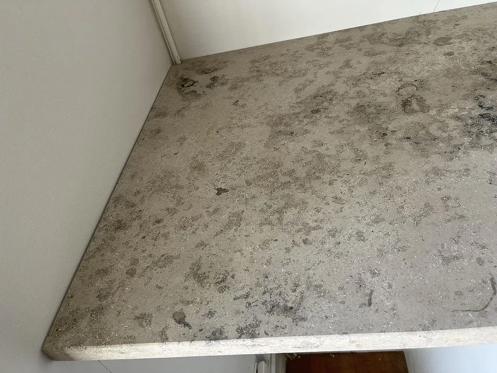 Närbild på matt Jura Grey köksbänkskiva i kalksten med fossila skalfragment i ett kök i Malmö.