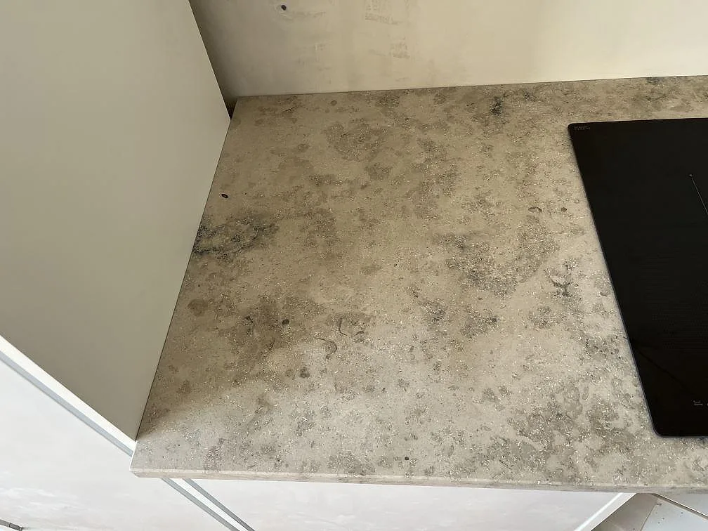Matt köksbänkskiva i Jura Grey med fossila flecks och nedsänkt induktionshäll, monterad i ett kök i Malmö.
