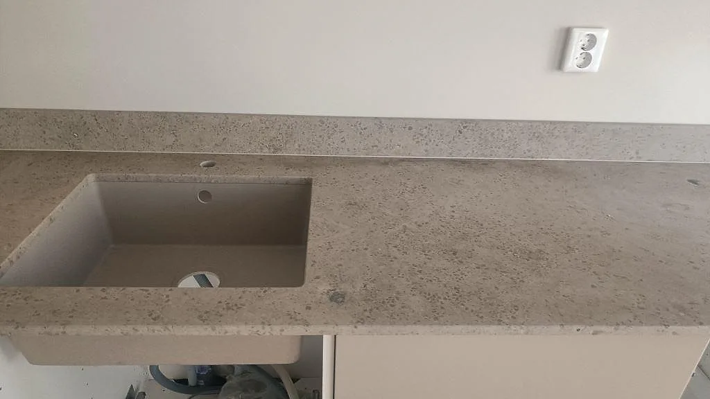 Underlimmad rostfri diskho i en matt Jura Grey köksbänkskiva med uppvikt stänkkant i Malmö.