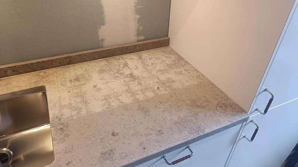 Diskbänksdel i matt Jura Grey kalksten med rostfri underlimmad diskho, vit inredning och stänkkant i Malmö.