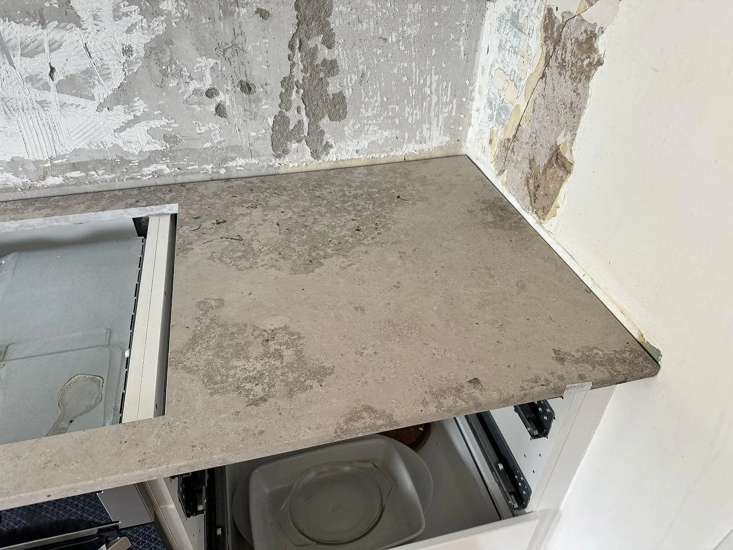 Hörnvy av matt Jura Grey köksbänkskiva i grå kalksten på öppna köksstommar under montering i Malmö.