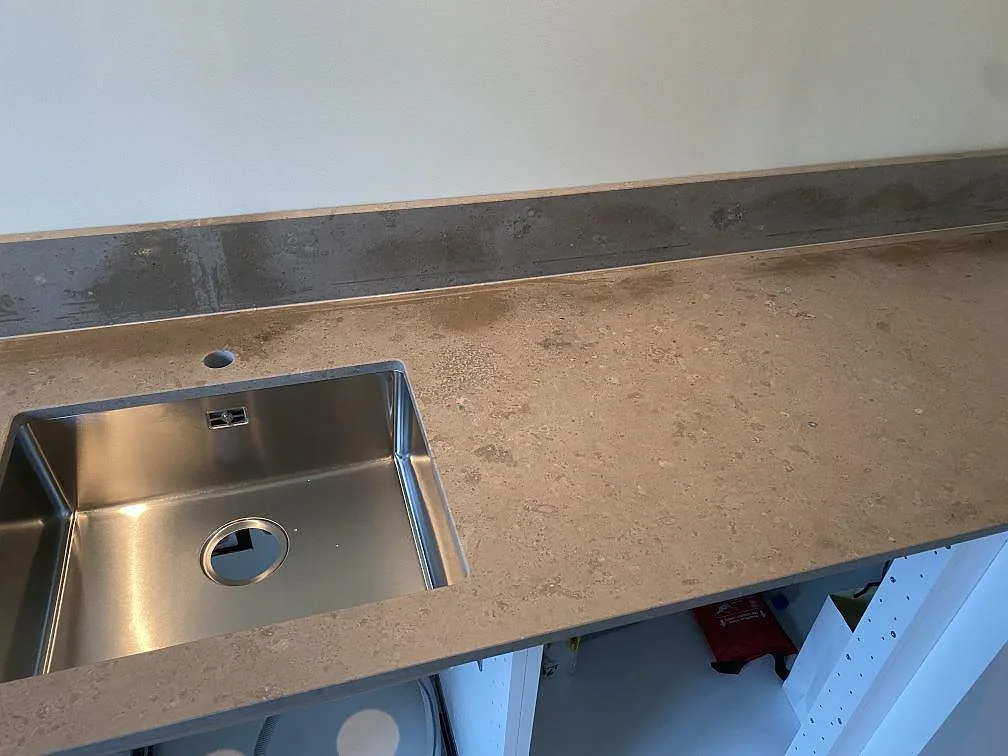 Köksbänkskiva i matt Jura Grey kalksten med rostfri diskho och grå stänkkant i Malmö.